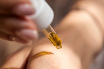 person putting hemp seed oil on their hand